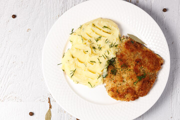 Breaded pork chop with mashed potatoes.