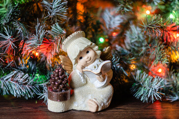 Christmas tree toy in the form of a figurine of an angel against the background of flickering...