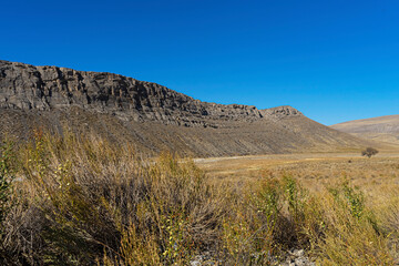 Mountains in the fall. Karatau mountains in southern Kazakhstan. Mountain plants in autumn. Rocks. Mountain stones. Rocks. Dry grass. Blue sky