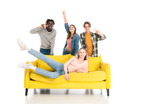  Cheerful Multiethnic Teenagers Showing Peace Gesture On Yellow Couch On White Background