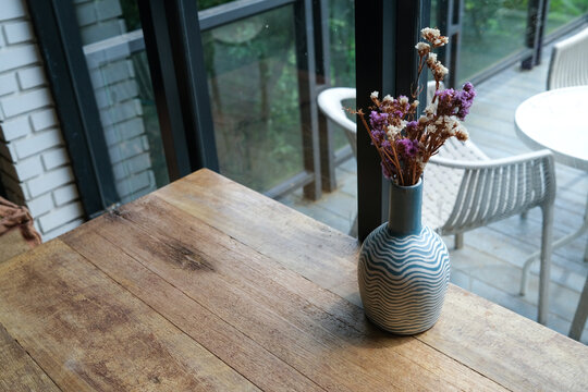 selective focus on lilac flowers in a ceramic vase on the wooden table