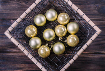 Christmas tree balls in a basket on a wooden background close up