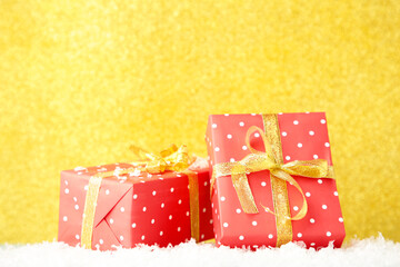A beautiful red gift on gold glitter background.