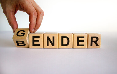 Male hand flips a wooden cube and changes the inscription 'bender' to 'gender' or vice versa....