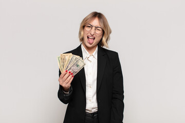 young blonde woman with cheerful, carefree, rebellious attitude, joking and sticking tongue out,...