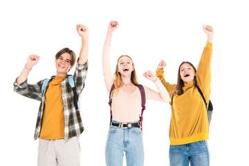 Fototapeta premium Excited teenagers with backpacks showing yes gesture and looking at camera isolated on white