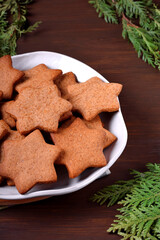 Gingerbread star cookies on the ceramic plate on the wooden table. Christmas pastry