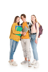 Smiling teenagers with backpacks and notebooks looking at camera on white background