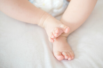 Fototapeta na wymiar Small baby girl feet on the bed