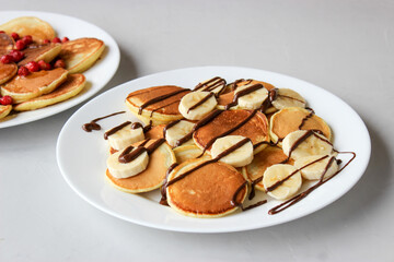 Mini pancakes with fruit drizzled with chocolate and honey