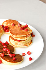 Mini pancakes with fruit drizzled with chocolate and honey