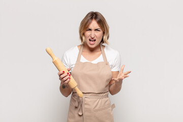 young blonde woman looking angry, annoyed and frustrated screaming wtf or what’s wrong with you