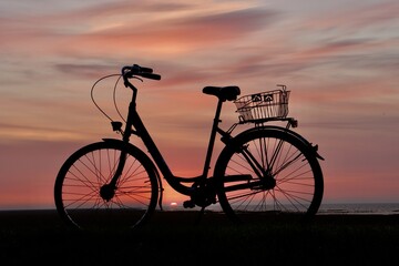 Naklejka na ściany i meble silhouette of a bike in the sunrise