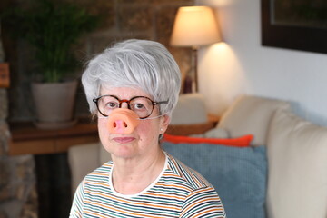 Senior woman wearing cute pig nose
