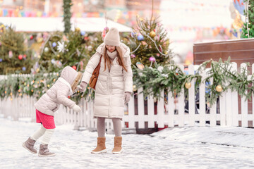 Cheerful family, mother and little girl having fun on Christmas market.