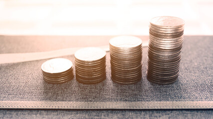 High angle view coins stack on the table with background sunlight from window, financial concept,