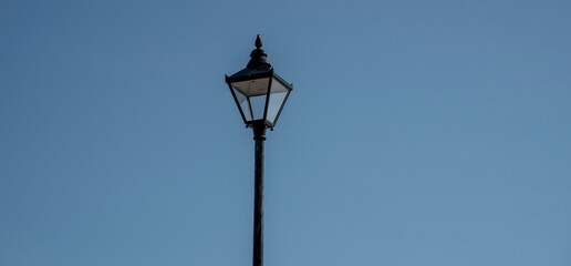 Fototapeta na wymiar UK. 2020. An old lamp light against a blue sky