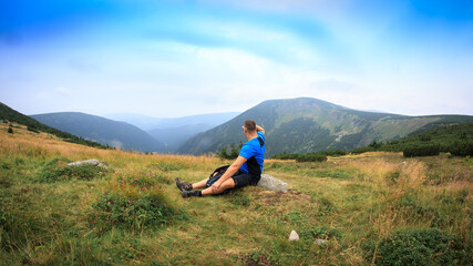 Górskie wędrówki. Mężczyzna na tle gór © Dariusz