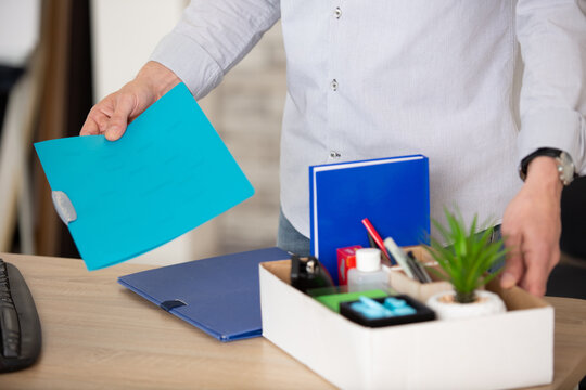 midsection view of a businessman tiddy belongings in cardboard box