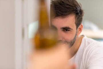Blurred silhouette of bottle of beer and young man on the background.