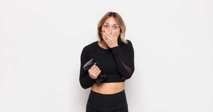 young blonde woman covering mouth with hands with a shocked, surprised expression, keeping a secret or saying oops