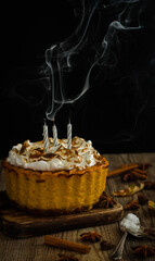 Homemade  pumpkin cheesecake on a dark and wood background.