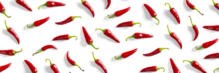 Creative background made of red chili or chilli on white backdrop. Minimal food backgroud. Red hot chilli peppers background. - obrazy, fototapety, plakaty