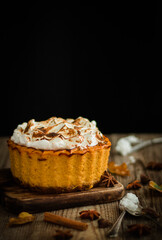 Homemade  pumpkin cheesecake on a dark and wood background.