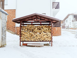 A street firebox filled with wood stands outside on a snowy winter day