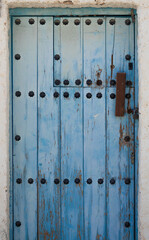 Blue solid door typical of old towns in Spain, very typical of Andalusia.