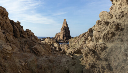 Fototapeta premium Beautiful pebble beach in the sirens reef with large rocks in the Mediterranean Sea, in Cabo de Gata, in Spain.