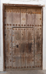 Brown solid door typical of old towns in Spain, very typical of Andalusia.