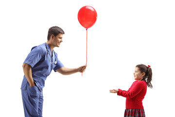 Doctor giving a red balloon to a little girl