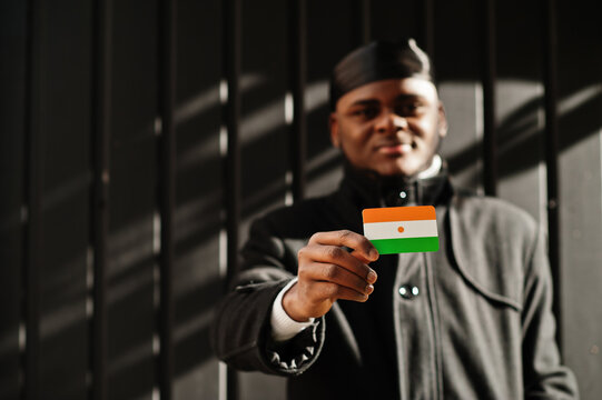 African man wear black durag hold Niger flag at hand isolated dark background.