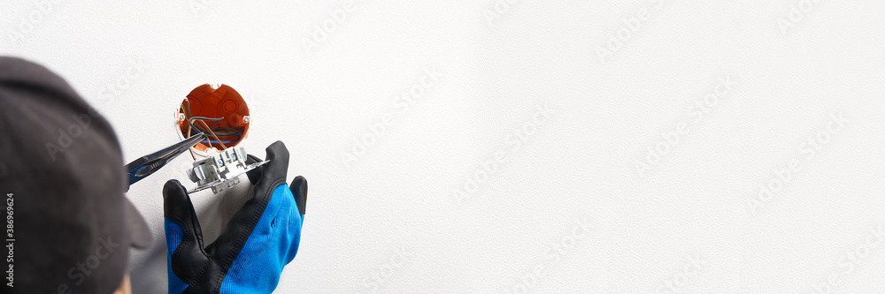Poster electrician installing light switch on painted wall with screwdriver. man installing light switch af