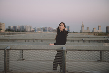 A young woman in a black hoodie. Sunset. On the streets.