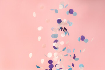 White, blue and lilac confetti on a pink background
