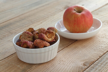 Dried apples in a white ceramic plate, selective focus.