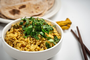 Kichari in a white plate near tortillas and sticks