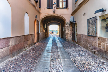 Fototapeta na wymiar Walking in the picturesque streets of Alghero, Sardinia, Italy