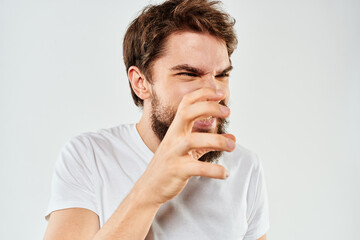 Bearded man gesturing with hands cropped view white t-shirt studio emotion light background