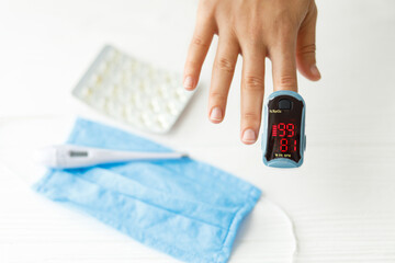Detecting coronavirus at home, injury lungs and pneumonia by virus. Pulse Oximeter on hand