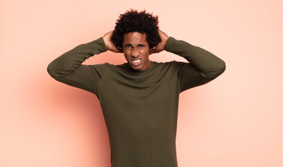 young black afro man feeling stressed, worried, anxious or scared, with hands on head, panicking at...
