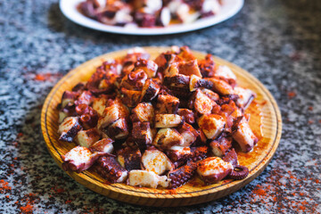 Octopus portions in a wooden plate. Seafood.