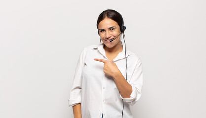 young hispanic woman looking excited and surprised pointing to the side and upwards to copy space