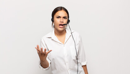 young hispanic woman looking angry, annoyed and frustrated screaming wtf or what’s wrong with you