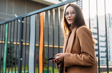 Beautiful young business woman executive is using an application in her smart phone to check email or send a text message.