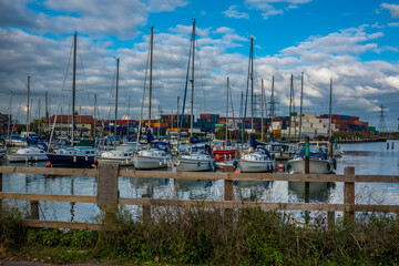 Fototapeta na wymiar A plethora of pleasure boats with a backdrop of containers at Eling Marina near Southampton, UK in Autumn