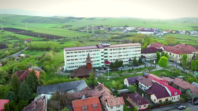 Huedin,Cluj/Romania-04.30.2020-Huedin city hospital-(Spitalul orasenesc Huedin) aerial photo, view from above. Gypsy houses in background.