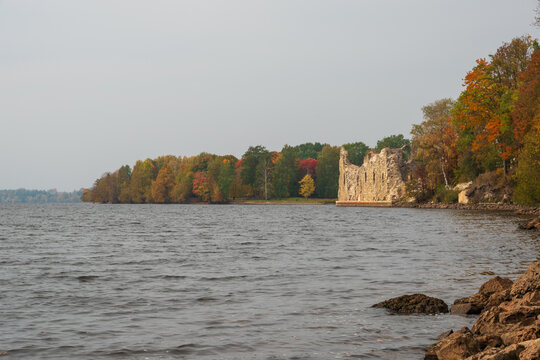 View to the Koknese Castle Ruins and Daugava river with colorful red and yellow trees around in autumn
